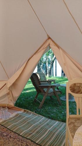 uma tenda com uma cadeira e uma rede de descanso na relva em Glamping tent Pielinen 