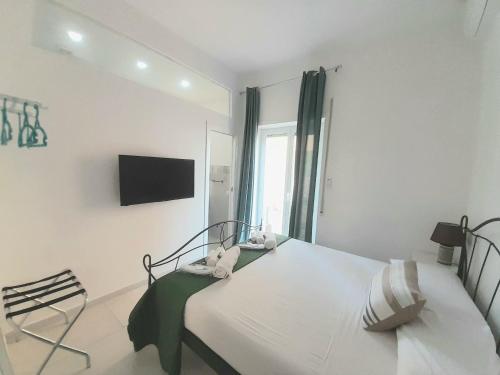 una camera bianca con letto e TV di Rome Sea 1 a Lido di Ostia