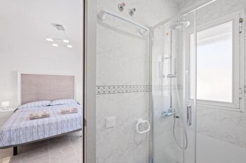 a white bathroom with a shower and a bed at Villa Montelimar - Biznaga Rental Homes in Rincón de la Victoria