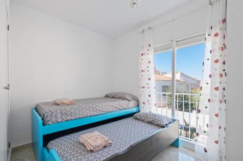 a bedroom with two bunk beds and a balcony at Villa Montelimar - Biznaga Rental Homes in Rincón de la Victoria