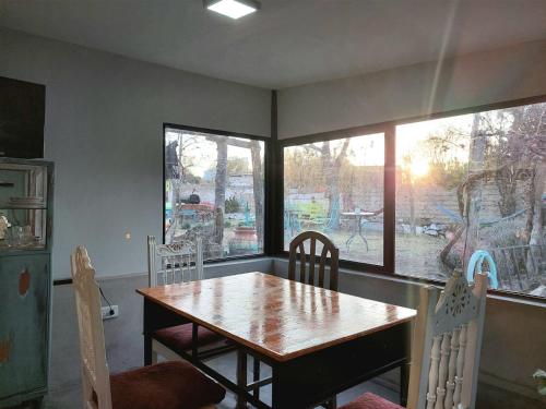 卡法亞特的住宿－Huaka Hostal，一间带桌椅和窗户的用餐室