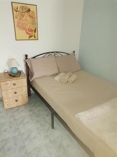 a bed with two pillows and a nightstand next to a bed at Spitaki mou in Kamena Vourla