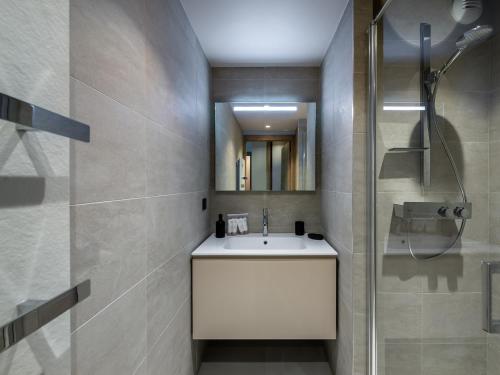 une salle de bain avec un lavabo et une douche dans l'établissement Appartement à Megève avec espace bien-être, piscine, sauna et salle de sport - FR-1-569-35, à Megève