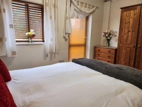 a bedroom with a large white bed and a window at * Cotswolds Get-Away Annex * in Cleeve Prior