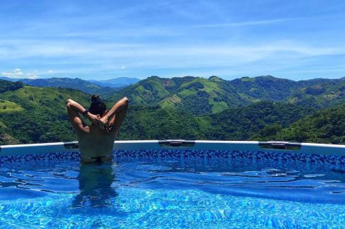 a person sitting on a dolphin in a swimming pool at Casa Kakawa Ecolodge in Samaná