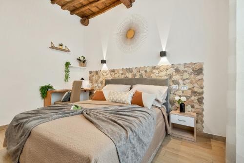 a bedroom with a large bed and a stone wall at Alby Express Rooms in La Spezia