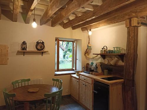 une cuisine avec une table et une table et une fenêtre dans l'établissement Domaine de la Comté - Hébergements insolites & Spa, à Le Louverot
