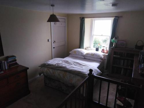 ein kleines Schlafzimmer mit einem Bett und einem Fenster in der Unterkunft Threecrofts Farm in Dumfries