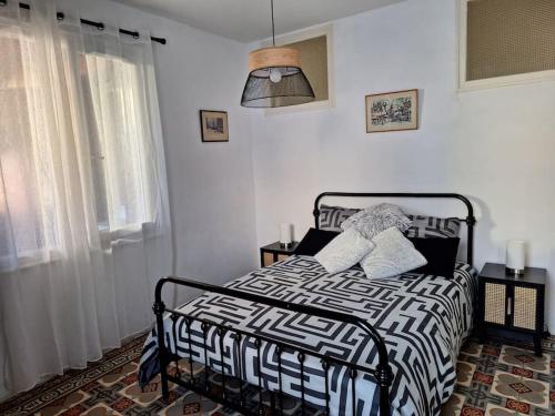 une chambre avec un lit avec une couette noire et blanche dans l'établissement Self Contained City Apartment, à Perpignan