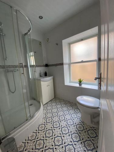 a bathroom with a shower and a toilet and a sink at Wards House Loft Apartment, Matlock in Matlock