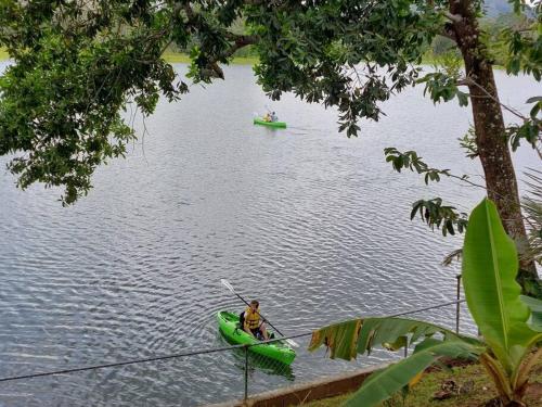 a man in a green kayak on a lake at Chagres River Lodge in Santa Rosa