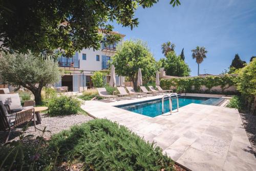 a swimming pool with lounge chairs next to a building at Nema Boutique Hotel & Spa in Artá