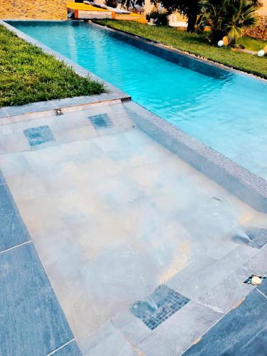 a swimming pool with blue water in a yard at Mas L'Escale des Dentelles in Aubignan