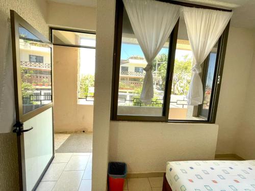 a bedroom with a bed and a window with a view at Hotel Bigu in Puerto Escondido