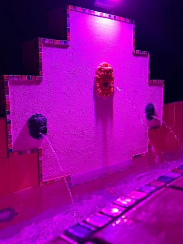 a pink wall with a fire hydrant in front of it at Agrolea in Terme Vigliatore