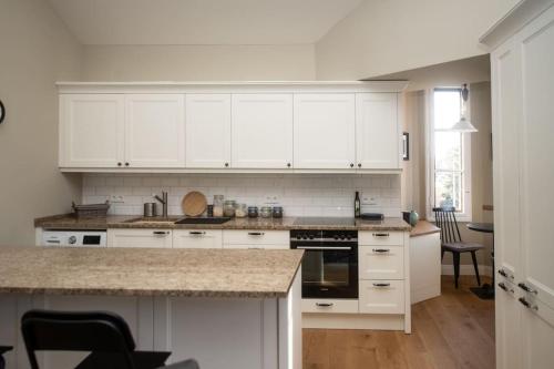 a kitchen with white cabinets and a counter top at A Refuge Built for a King in Halbe