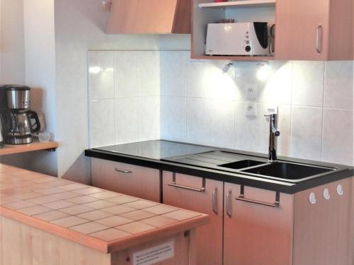 une cuisine avec un évier et un plan de travail dans l'établissement Appartement cosy 6 pers. proche pistes avec balcon, casier à skis et parking couvert - FR-1-573-32, à Saint-Jean-dʼAulps