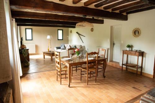 een woonkamer met een houten tafel en stoelen bij L'Aube Normande 