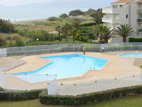 une grande piscine entourée d'une clôture. dans l'établissement Appart 2P/6 Pers avec Piscine et Parking à Saint-Cyprien - FR-1-225D-106, à Saint-Cyprien