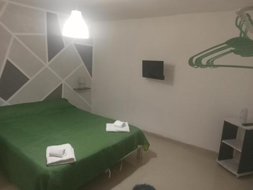 a room with a green bed with two white towels at Il cortiletto Haus in Catania