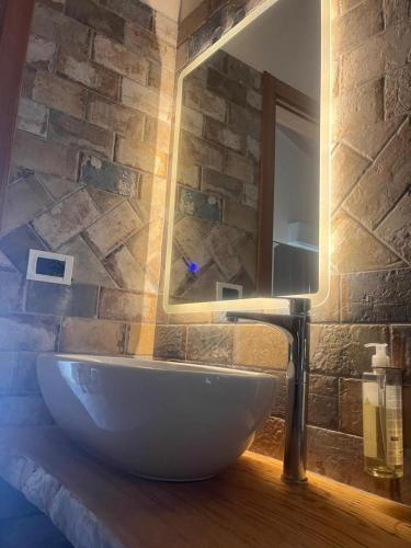 a bathroom with a white sink and a brick wall at Incanto Glamping village in Savio di Ravenna