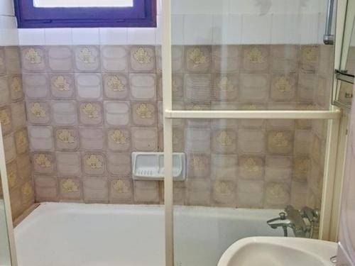 ein Badezimmer mit einer Badewanne und einem Waschbecken in der Unterkunft Studio Bormes-les-Mimosas, 1 pièce, 4 personnes - FR-1-610-17 in Bormes-les-Mimosas