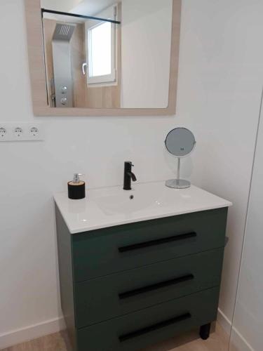 uma casa de banho com uma cómoda verde e um espelho em Ático en el centro de Estella em Estella