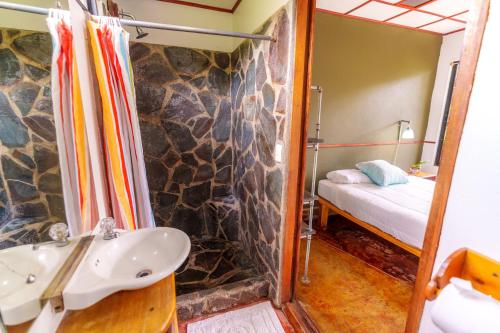 a bathroom with a sink and a bed in a room at Pension Santa Elena in Monteverde Costa Rica