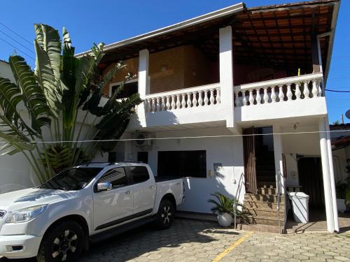 a white truck parked in front of a house at Pousada Novo Encanto Maresias in Maresias