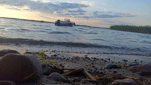a boat on the shore of a body of water at Dom Królewski Róg in Giżycko
