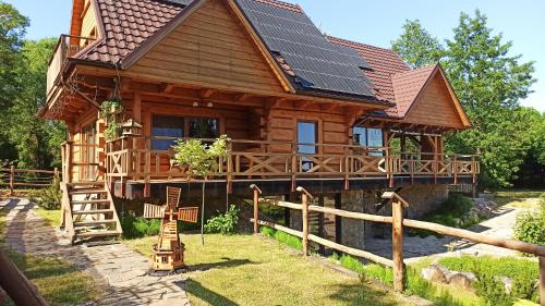 a log cabin with solar panels on the roof at Dom Królewski Róg in Giżycko