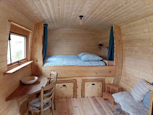 Cette petite cabine comprend un lit et une table. dans l'établissement Domaine de la Comté - Hébergements insolites & Spa, à Le Louverot