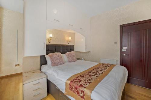 a bedroom with a large white bed with pink pillows at Luxury Oceana Apartment, Central City Centre, Newly Refurbished in Plymouth