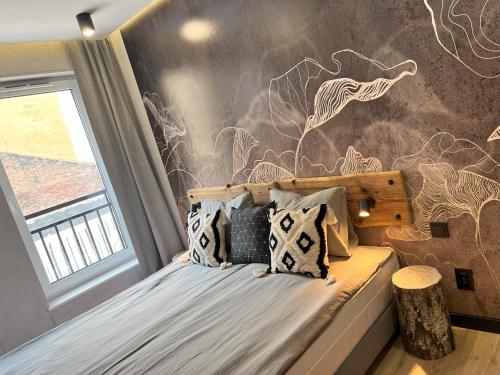 sypialnia z łóżkiem z malowidłem ściennym w obiekcie Hi Apartments Kozia w Kielcach
