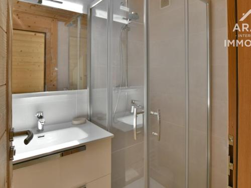 een badkamer met een wastafel en een glazen douche bij Appartement Le Grand-Bornand, 4 pièces, 6 personnes - FR-1-391-134 in Le Grand-Bornand