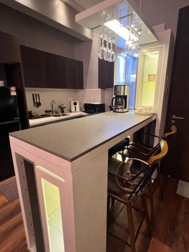 eine Küche mit einer Theke und Stühlen in einem Zimmer in der Unterkunft Troika Avenue Kota Bharu by The Stay Homestay 2 in Kota Bharu