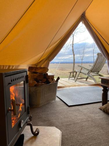a tent with a fireplace and a view of the desert at Glamping 4 saisons @ Eco Lodge Bûcheron Bergère in Ormstown