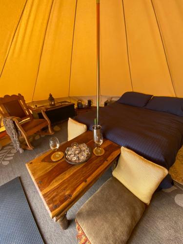 Una habitación con una cama y una mesa en una tienda de campaña en Glamping 4 saisons @ Eco Lodge Bûcheron Bergère, en Ormstown