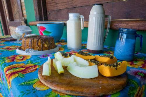 een tafel met een snijplank met voedsel erop bij Pousada Luz da Vila Itaúnas in Itaúnas