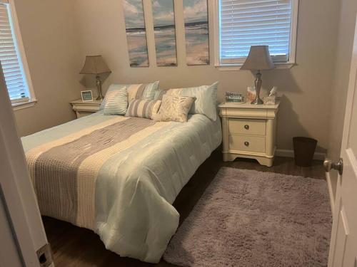 a bedroom with a bed with two night stands and two windows at Papa's Escape in Brunswick