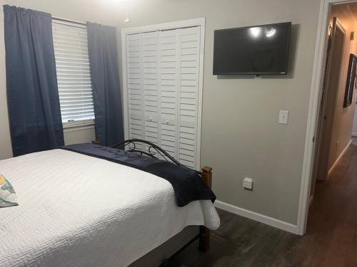a bedroom with a bed and a television on a wall at Papa's Escape in Brunswick