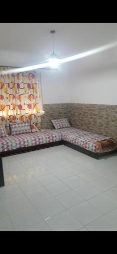 een kamer met 2 bedden in de hoek van een kamer bij السعيدية in Saidia 