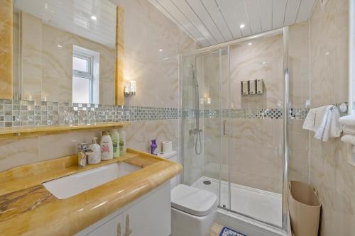 een badkamer met een douche, een wastafel en een toilet bij Luxury Mayflower Apartment, Central City Centre, Newly Refurbished in Plymouth