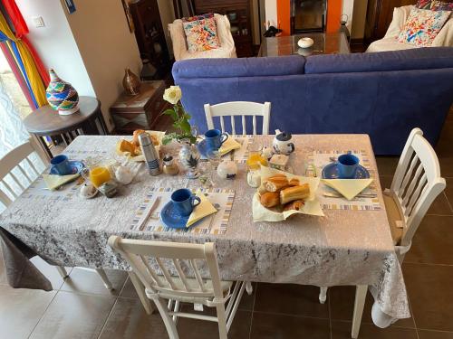 mesa de comedor con comida y sofá azul en La Marine Louannec, en Louannec