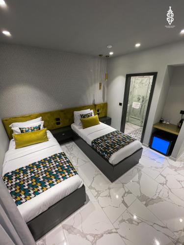 two beds in a room with a marble floor at Saladin Boutique Hotel in Jerusalem
