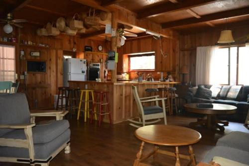 ein Wohnzimmer mit einem Sofa und Stühlen sowie eine Küche in der Unterkunft Charming 1927 Lake Front Home - Hargrave in Bass Lake