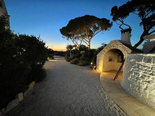 a driveway leading to a house with a stone archway at Masseria Grofoleo in Locorotondo