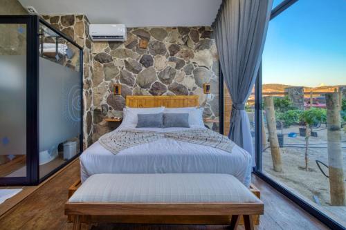 a bedroom with a bed and a large window at Sirius Valle in Valle de Guadalupe