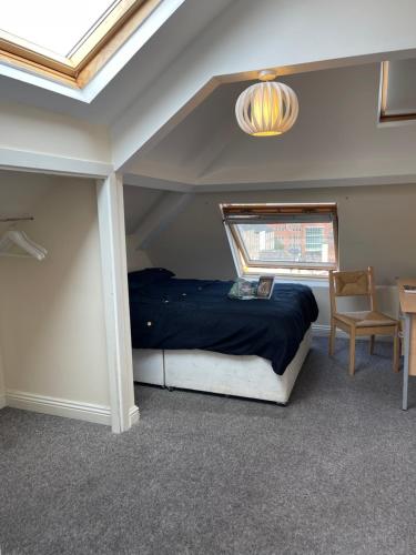 a bedroom with a bed and a window and a table at Cosy Room in city centre in Newcastle upon Tyne