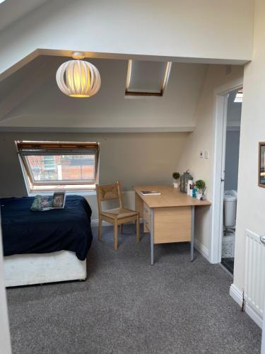 una camera con letto, scrivania e tavolo di Cosy Room in city centre a Newcastle upon Tyne